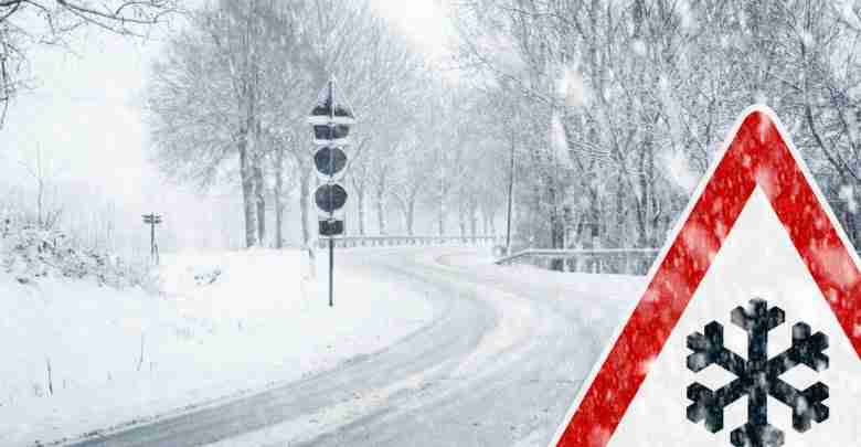 Snowy curvy road with traffic sign