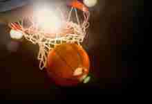Basketball going through the basket at a sports arena (intention