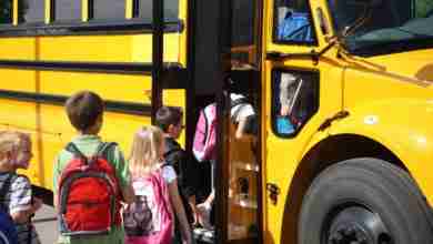 Elementary school students getting on school bus