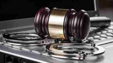 handcuffs and judge gavel on computer concept
