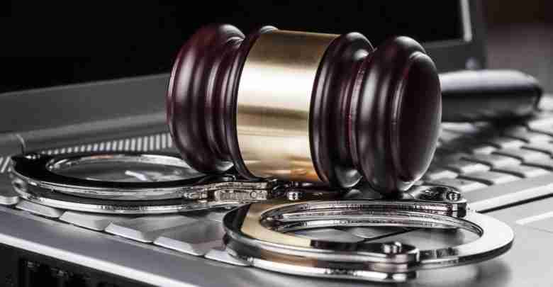 handcuffs and judge gavel on computer concept