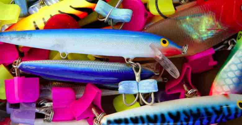 Colorful fishing saltwater fish lures in a box, rusted hooks