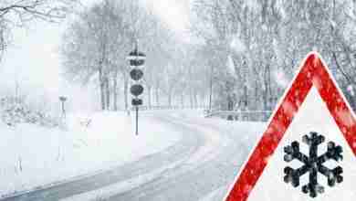 Snowy curvy road with traffic sign
