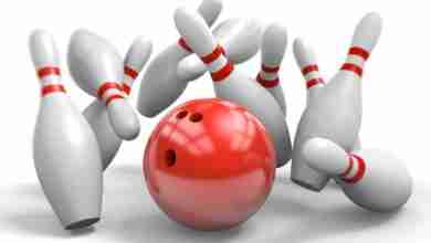 Red bowling ball knocking over pins in a perfect strike