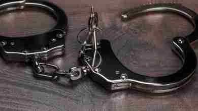 handcuffs and keys on brown wooden table background