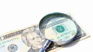 Money Under Magnify Glass Isolated Over White